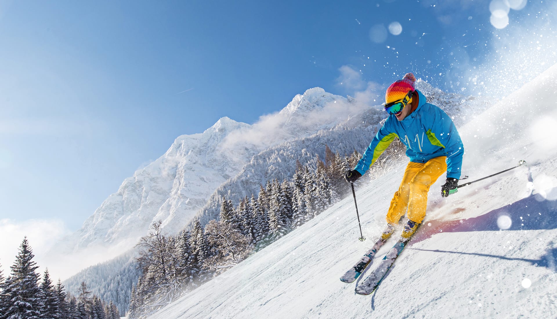 Skier skiing downhill in high mountains.