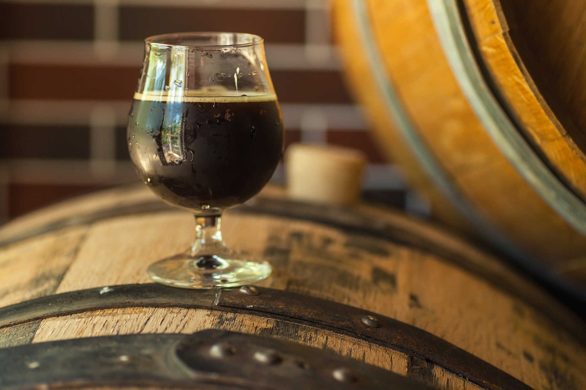 Dark beer sitting on a whiskey barrel